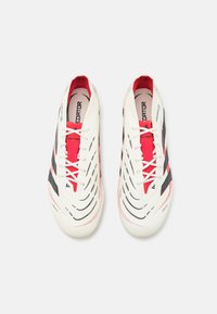White and red athletic shoes with a sleek design, featuring black accents and a textured, layered upper. Laces are white with red detailing.