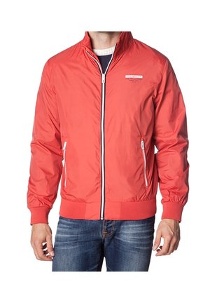 Chaqueta ligera roja con cierre frontal de cremallera, puños y dobladillo acanalados, dos bolsillos laterales con cremallera y un logo en el pecho.