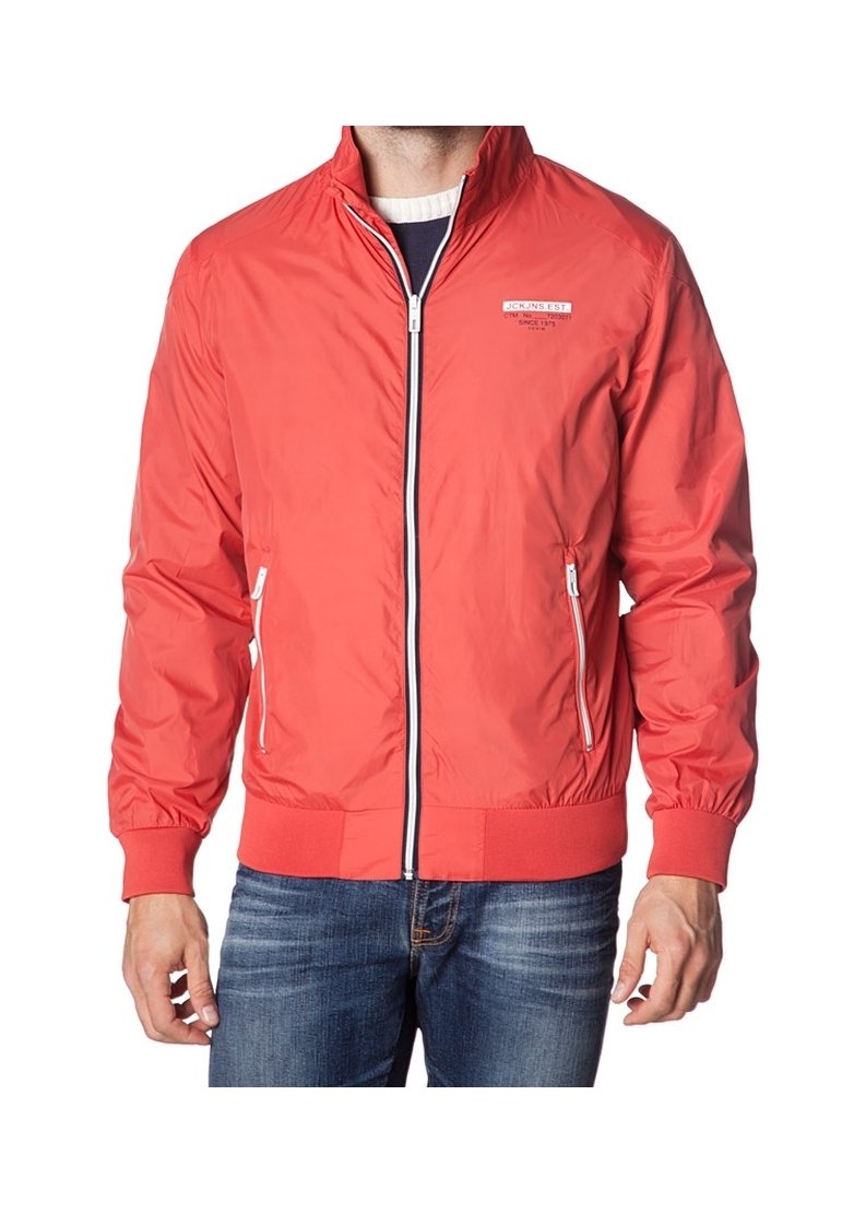 Veste légère rouge avec fermeture éclair à l'avant, poignets et ourlet côtelés, deux poches latérales zippées et un logo sur la poitrine.
