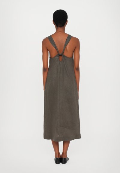 Mørk olivengrønn linadress med bakbinding og utskåret nøkkelhull, med rett silhuett og kne-lengde hem.