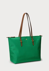 Grønn totebag laget av teksturert stoff, med brune lærreimer, gullhardware og detalj med logo på fronten.