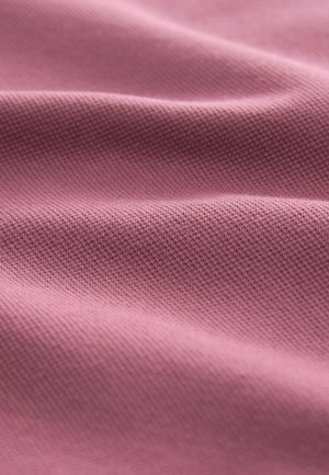 Tessuto rosa chiaro con una trama sottile, che presenta pieghe morbide e ondulate e una superficie liscia.
