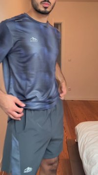 Tenue de sport pour homme comprenant un haut ajusté à manches courtes bleu marine avec un motif texturé et un short gris avec poches latérales et détails de logo.