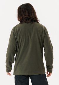 Pulóver de forro polar verde oliva con mangas largas, escote redondo y corte relajado, que presenta una textura suave y un dobladillo ligeramente curvado.