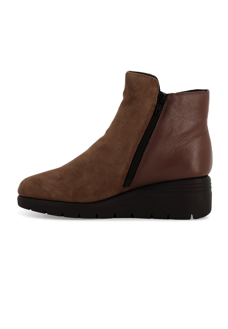 Stivale alla caviglia marrone con finitura scamosciata, zip laterale e tacco a zeppa. Punta arrotondata e suola in gomma nera con grip testurizzato.
