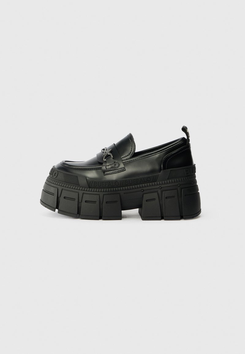 Loafer preto robusto com plataforma grossa, sola texturizada e detalhe de fivela no vamp, nome da marca embutido no meio da sola e laço de puxar no calcanhar.