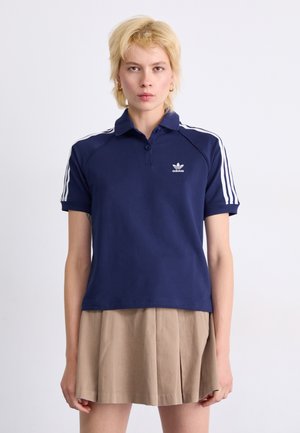 Mørkeblå polo shirt med krave, der har hvide tre-stribet detaljer på skuldrene og et broderet logo på brystet.