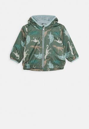 Veste verte avec des motifs de dinosaure, en matériau léger, design à capuche, fermeture éclair, poignets élastiques et doublure intérieure lisse.