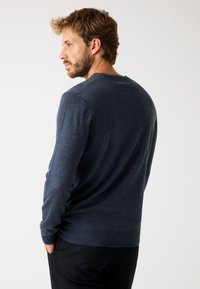 Maglione blu navy, maniche lunghe, collo a giro, texture a maglia fine, polsini e orlo a coste sottili, vestibilità standard. Nessun logo o design visibile.