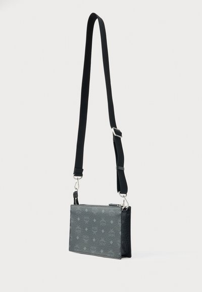 Μαύρη τσάντα ώμου με υφή γκρι μοτίβο, ορθογώνιο σχήμα, ρυθμιζόμενο λουρί και ασημένιες μεταλλικές λεπτομέρειες.