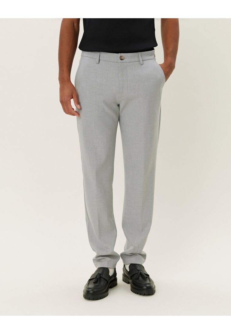 Light gray tailored trousers with a smooth texture, slim fit, and a single button closure. Paired with black loafers for contrast.