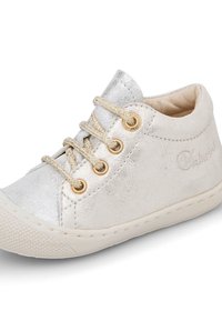 Metalické stříbrné tenisky s měkkým svrškem, zlatými očky a texturovanou gumovou podrážkou; obsahují krémové tkaničky a jemný branding.