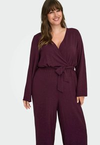 Bordeaux jumpsuit met een wikkelontwerp, lange mouwen en een strikceintuur; gemaakt van een textured stof met subtiele glansdetails.