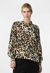 Leeuwenspots blouse in beige, bruin en zwart; heeft een klassieke kraag, lange puffmouwen en een knoopsluiting aan de voorkant. Soepele, lichte stof.