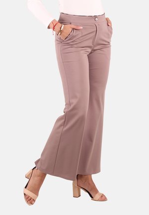 Woman wearing mauve high-waist flare pants with side pockets, paired with beige block-heel sandals and a white top.