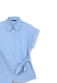 Blusa azzurro chiaro a maniche corte con colletto, bottoni frontali e dettaglio annodato di lato. Il tessuto appare liscio con una finitura opaca.