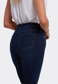 Donker denim hoge taille jeans met een gladde textuur, voorzien van twee achterzakken en subtiele stiksel details.