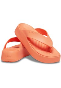 Chanclas naranjas hechas de un material ligero y flexible con una plantilla acolchada, que presentan un diseño minimalista y un logo en el lateral.