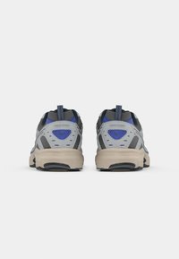 Gray athletic shoes with blue accents, mesh upper, padded collar, and textured rubber sole, featuring a prominent back tab for easy wear.