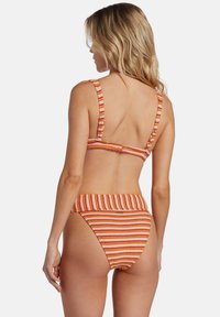 Zúžený bikiny set s oranžovými a bielymi vodorovnými pruhmi, vyrobený z textúrovanej látky, s nastaviteľnými ramienkami a vysokými spodnými dielmi.