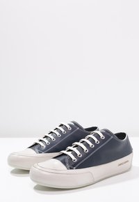 Scarpe in pelle blu navy con suole e lacci in gomma bianca, caratterizzate da cuciture a contrasto e un design a punta rotonda. Logo "Candice Cooper" sul lato.