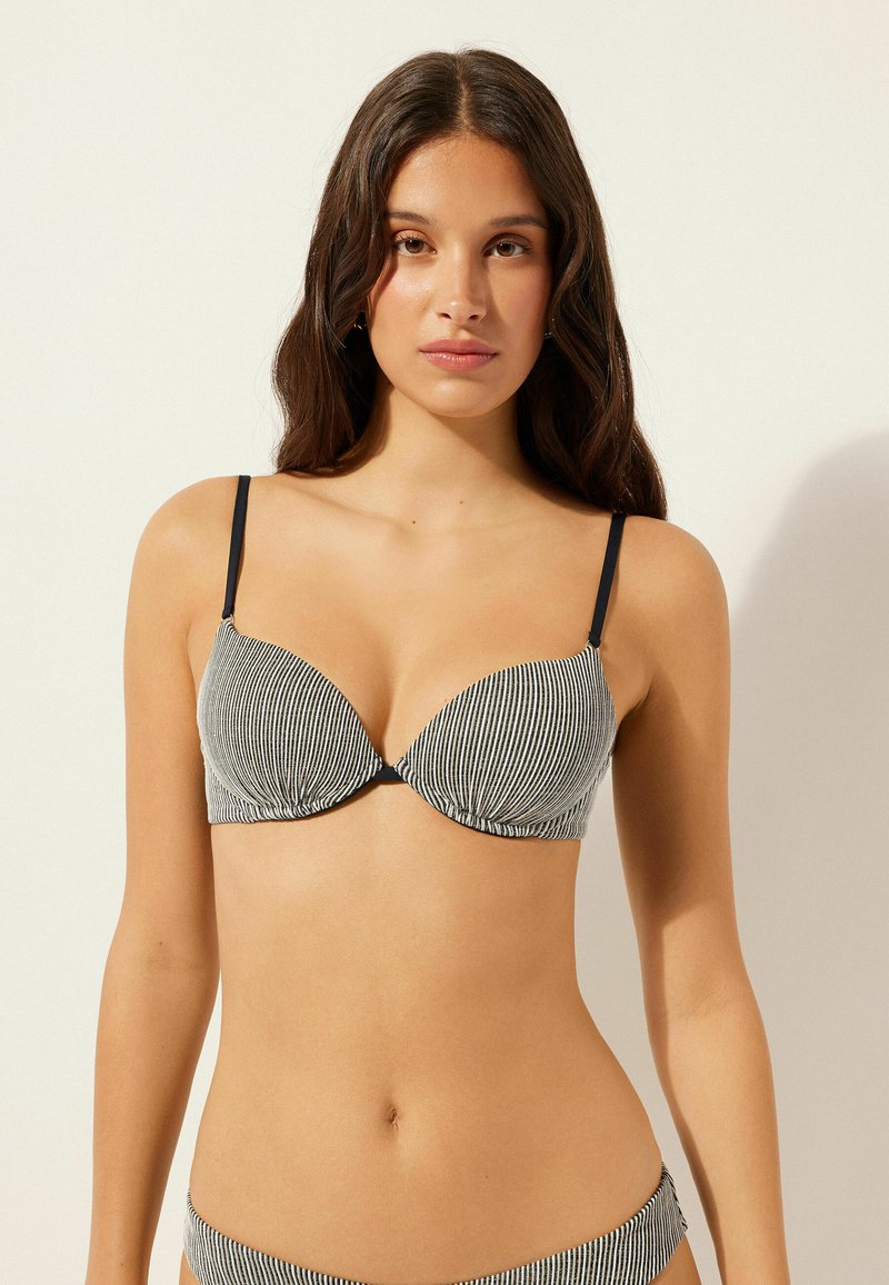 Schwarz-weiß gestreiftes Bikinioberteil mit V-Ausschnitt, Soft-Cup-Design, verstellbaren Trägern und gerafften Vorderdetails.
