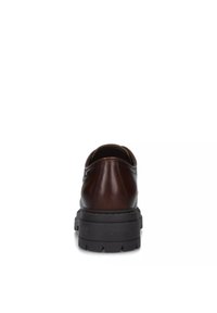 Zapato de cuero marrón con punta redondeada y suela de goma negra gruesa, mostrando una textura suave y un detallado mínimo. Vista trasera.