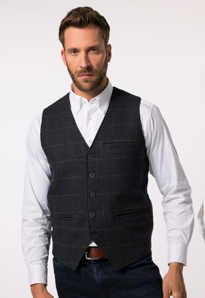 Gilet en mélange de laine gris foncé avec un motif à carreaux verts, présentant un col en V, cinq boutons et deux poches avant, porté sur une chemise blanche.
