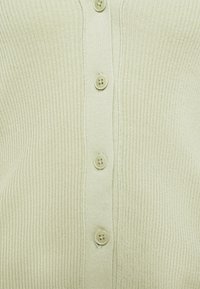 Hellgrüner, gerippter Cardigan mit V-Ausschnitt und sechs passenden Knöpfen entlang der Vorderseite. Die Textur ist weich und fein gestrickt.