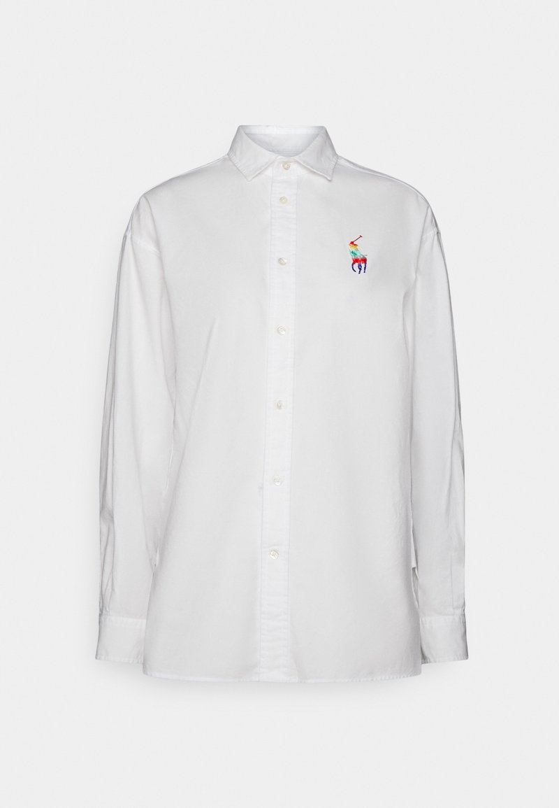 Vit skjorta med knappar, tillverkad av bomull, med långa ärmar, en spetsig krage och en färgglad broderad logotyp på vänster bröst.