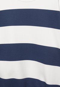 T-Shirt mit breiten horizontalen Streifen in Marineblau und Weiß, flach auf einem einfarbigen Hintergrund ausgelegt.
