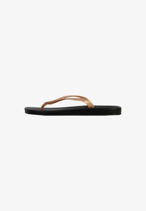 Chanclas negras con suela texturizada, que presentan una delgada tira metálica de cobre. Diseño elegante y minimalista sin patrones ni acentos adicionales.