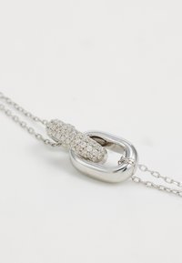 Collar de plata con un eslabón texturizado y brillante y un eslabón ovalado liso, ambos conectados por una delicada cadena.