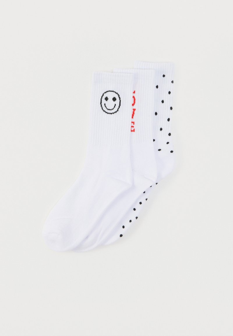 Chaussettes en coton blanc avec un visage souriant sur une chaussette et des pois noirs sur l'autre, avec un texte rouge indiquant "LOVE" sur le côté.