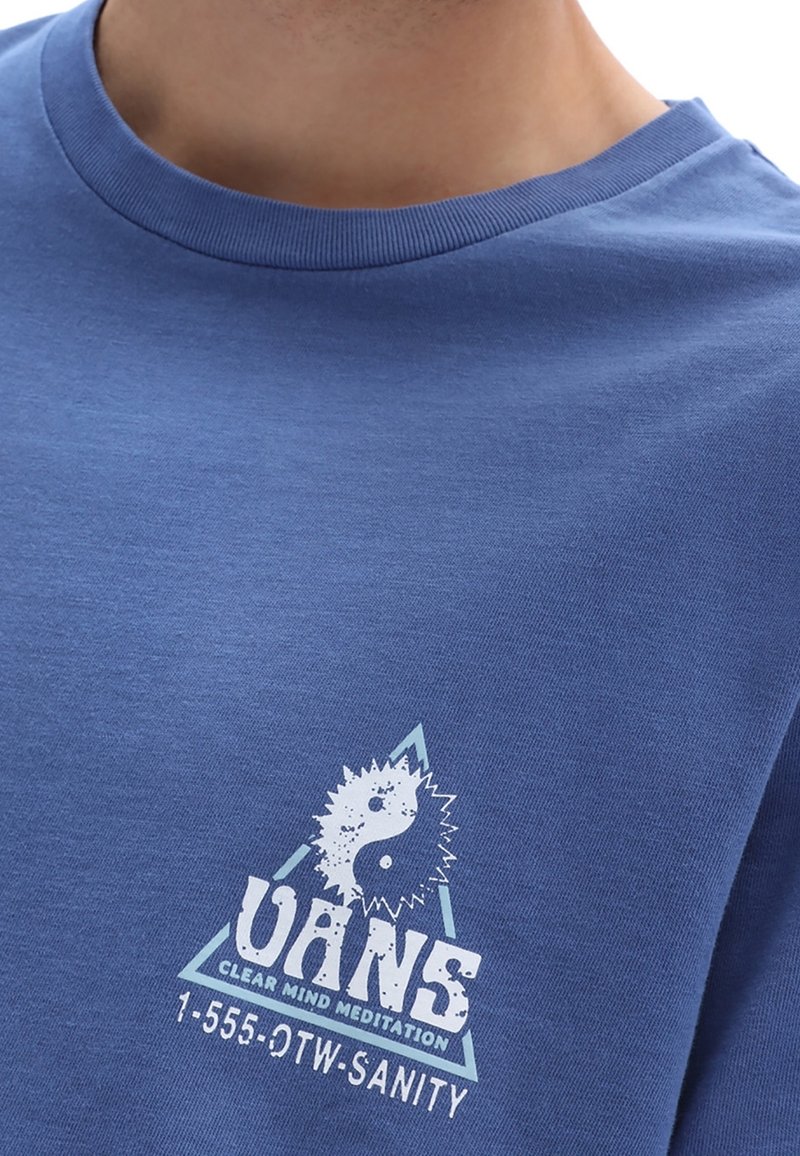 T-shirt en coton bleu avec un imprimé graphique blanc représentant un symbole yin-yang, un motif triangulaire et le texte "VANS CLEAR MIND MEDITATION."