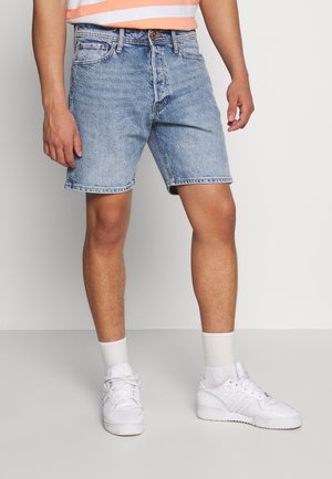 Vaaleansiniset farkkushortsit, joissa on rento leikkaus, revenneet reunat, viisi taskua. Yhdistettynä valkoisiin lenkkareihin ja valkoisiin nilkkasukiin.