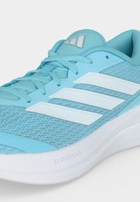 Ανοιχτό μπλε παπούτσι τρεξίματος Adidas με λευκές ρίγες, ανοιχτό μπλε κορδόνια και λευκή, μαξιλαρωμένη σόλα με ετικέτα "Cloudfoam."