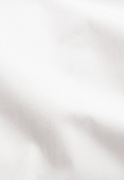 Gładka biała tkanina z delikatnymi fałdami i subtelnymi cieniami, podkreślająca jej fakturę i łagodny układ.