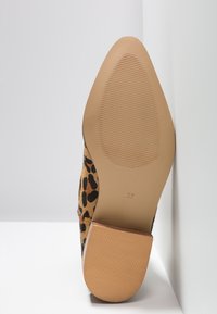 Semelle d’une chaussure à bout pointu imprimé léopard avec semelle beige texturée et talon bloc, taille marquée 37.