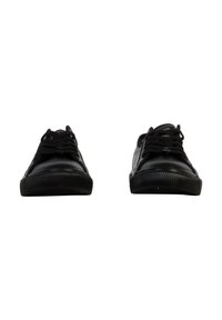 Chaussures de sport noires en matériau synthétique lisse. Bout rond, semelle en caoutchouc plate avec texture nervurée, et design de laçage traditionnelle.