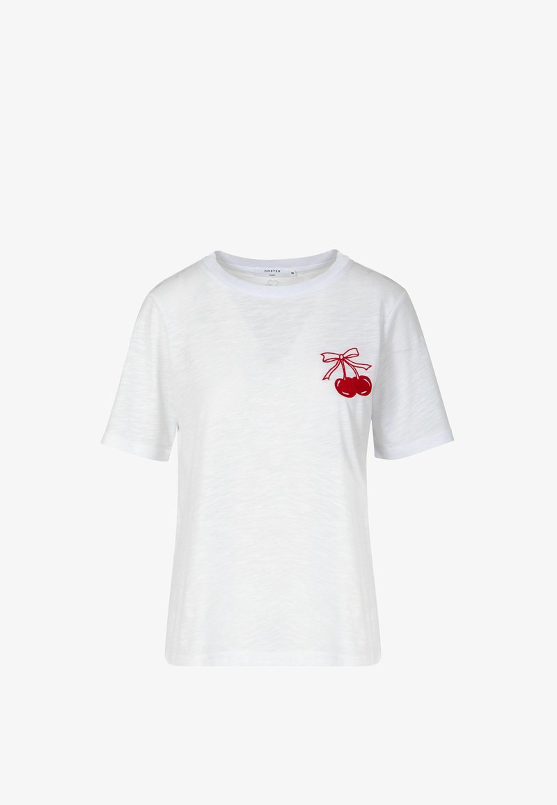 Λευκό T-shirt με κοντό μανίκι και μικρό κόκκινο σχέδιο κερασιού δεμένο με φιόγκο στην αριστερή πλευρά του στήθους, απλό φόντο.