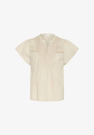 Kremasta bluzica s kratkimi nadležnimi rokavi, ki ima izrez v obliki žlice, gubano sprednjo stran in dekorativne vodoravne detajle. Mehka, lahka tkanina.