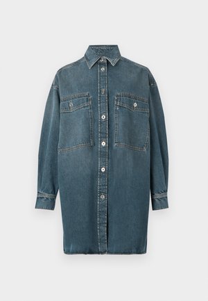 Chemise en denim bleu moyen avec une patte de boutonnage, manches longues, deux poches poitrine et un col classique. Tissu texturé avec des coutures renforcées.