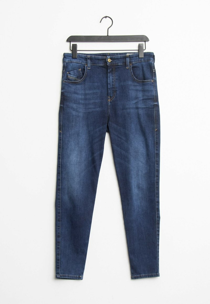 Jeans en denim bleu foncé avec cinq poches, design jambes droites, sections décolorées et fermeture à bouton en métal, suspendus à un porte-vêtements en plastique noir.