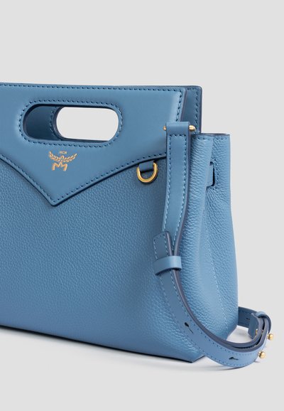 Hellblaue Lederhandtasche mit strukturiertem Finish, ausgestattet mit einem oberen Griff und einem verstellbaren Schulterriemen. Akzente in goldfarbener Hardware.