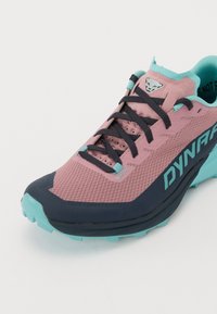 Trail running sko i rosa og marineblå, med et pustende mesh-overdel, polstret såle og forsterket tåhette. Turkise detaljer i designet.