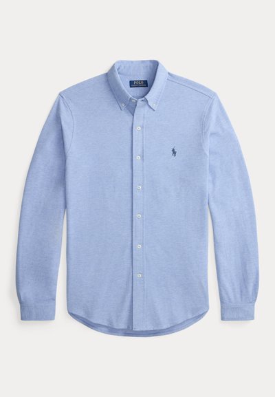 Light blue long-sleeve button-up shirt made of soft fabric. Features a classic collar, button closure, and embroidered logo on the chest.