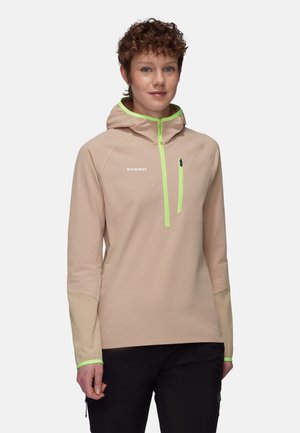Lichtbeige capuchonjack met een gestructureerd ontwerp, voorzien van neon groene accenten, een halve ritssluiting aan de voorkant en een ritszak op de borst.