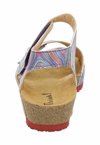Multicolored sandal with cork sole, adjustable back strap and buckle, textured insole, and red accent on the bottom. Features a wavy pattern.
