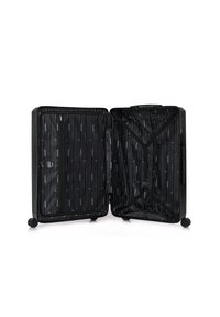Valise rigide noire, complètement ouverte avec deux compartiments. L'intérieur présente un motif rayé en gris et bleu, incluant des poches zippées et des sangles.